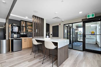 A modern kitchen with a bar area and a dining table.